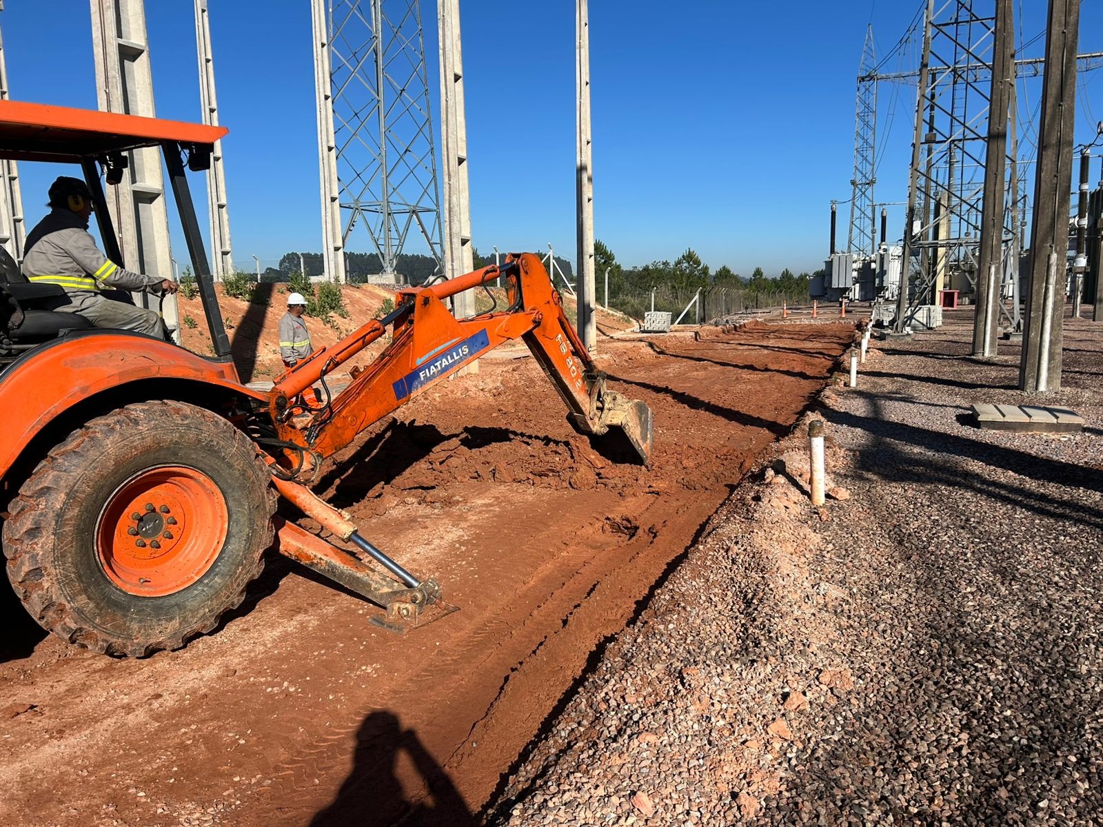 Construction worker kneeling to inspect newly laid asphalt surface, examining quality and texture with professional attention to detail